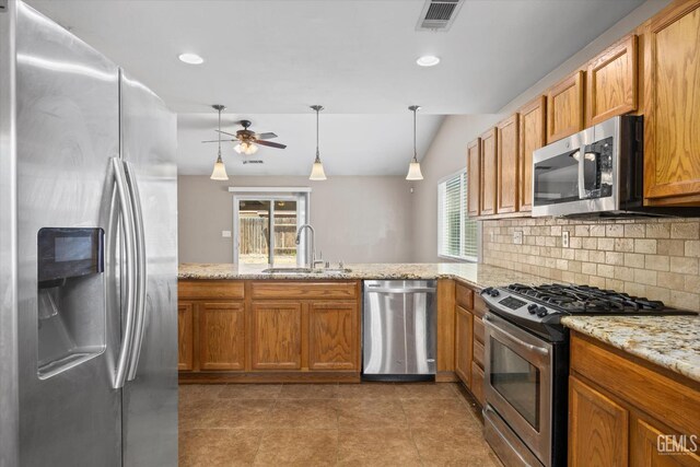 11602 Trabancos Dr, Bakersfield, CA 93311 - kitchen featuring appliances with stainless steel finishes, a peninsula, a ceiling fan, decorative backsplash, and brown cabinets