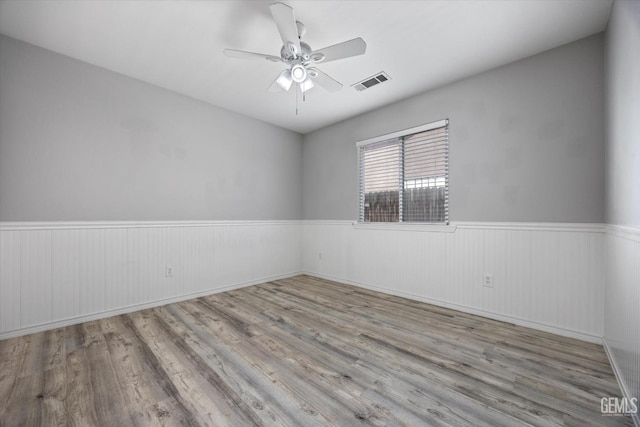 11602 Trabancos Dr, Bakersfield, CA 93311 - empty room featuring a wainscoted wall, ceiling fan, and wood finished floors