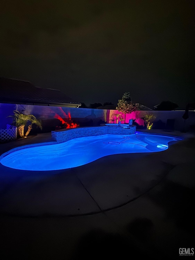 9311 Caliente Creek Ct, Bakersfield, CA 93311 - pool at night featuring a patio area and an outdoor pool