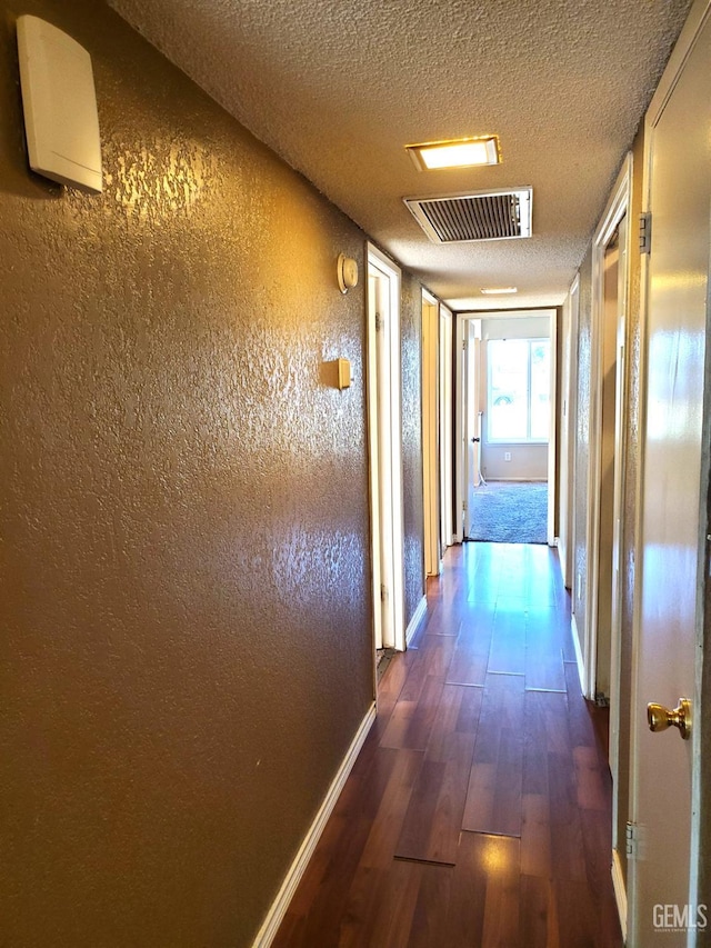 4204 Tyndall Ave, Bakersfield, CA 93313 - corridor featuring dark wood-style flooring, a textured ceiling, and a textured wall