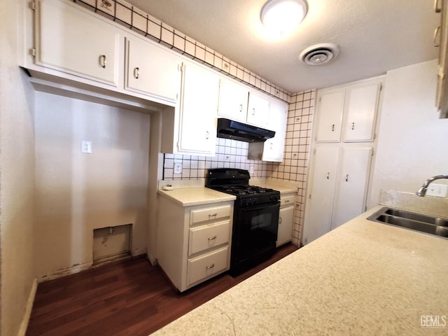 4204 Tyndall Ave, Bakersfield, CA 93313 - kitchen with gas stove, under cabinet range hood, dark wood finished floors, white cabinetry, and light countertops