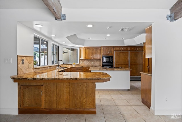 11717 Old Town Rd, Bakersfield, CA 93312 - kitchen with black appliances, a peninsula, stone countertops, decorative backsplash, and recessed lighting