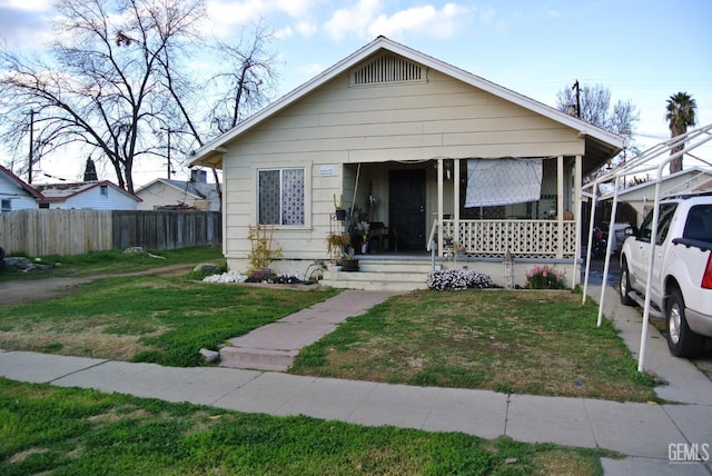 bungalow-style house with a front lawn and covered porch