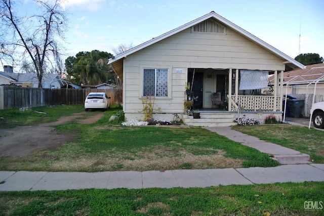 bungalow-style home with a front lawn and covered porch