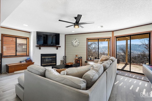 living room featuring a textured ceiling, a fireplace, and wood finished floors