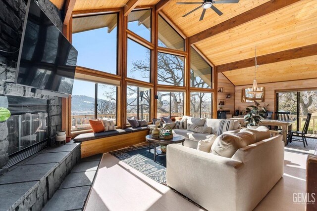 living area with high vaulted ceiling, wood ceiling, a fireplace, and beam ceiling