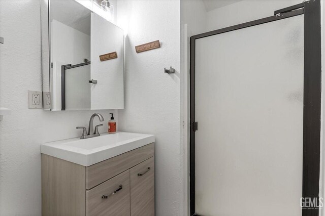 bathroom with a stall shower and vanity