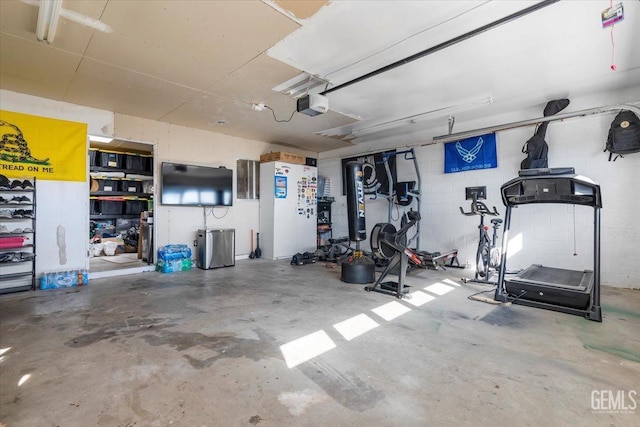 garage with concrete block wall and a garage door opener