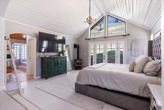 bedroom featuring arched walkways, lofted ceiling with beams, access to outside, french doors, and a chandelier