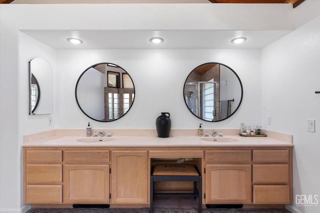 full bathroom featuring a sink, a shower stall, and double vanity