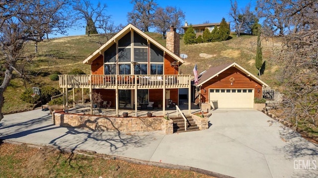 log home featuring driveway, stairway, a chimney, and a wooden deck