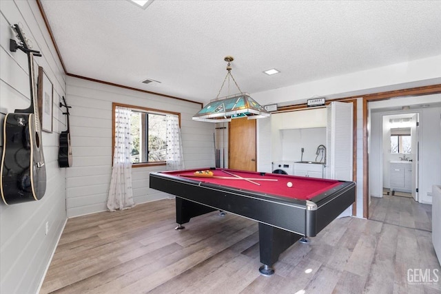 playroom with a sink, light wood-style flooring, billiards, and a textured ceiling