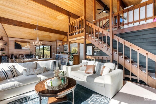 living room featuring stairway, wood ceiling, high vaulted ceiling, beamed ceiling, and ceiling fan with notable chandelier