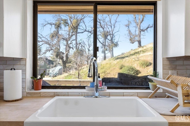 details with a sink and white cabinetry