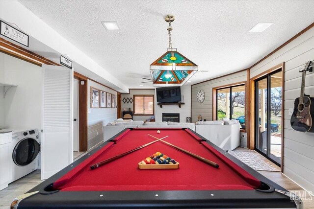 game room with a fireplace, wooden walls, a textured ceiling, and wood finished floors