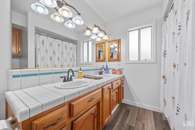 9913 Mark Twain Ave, Bakersfield, CA 93312 - full bathroom with double vanity, healthy amount of natural light, wood finished floors, and tasteful backsplash