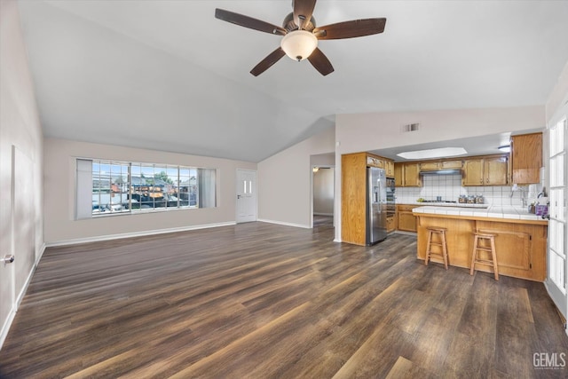 9913 Mark Twain Ave, Bakersfield, CA 93312 - unfurnished living room featuring lofted ceiling, dark wood-type flooring, and a ceiling fan