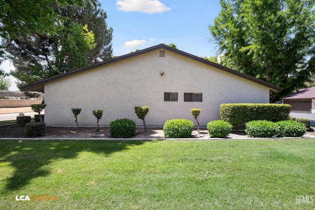 view of home's exterior with a lawn and stucco siding