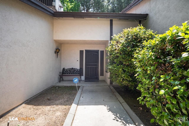 doorway to property featuring stucco siding