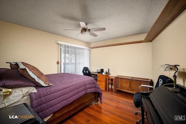 bedroom featuring a textured ceiling, wood finished floors, and a ceiling fan