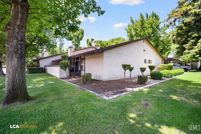 exterior space with a yard and stucco siding