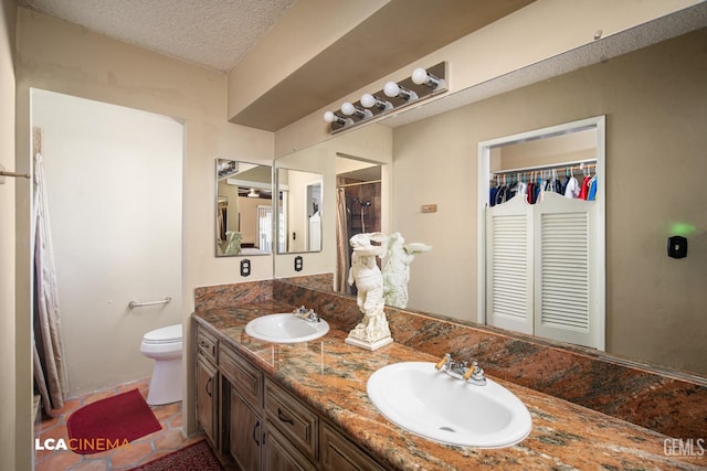 bathroom with toilet, a textured ceiling, a closet, and a sink
