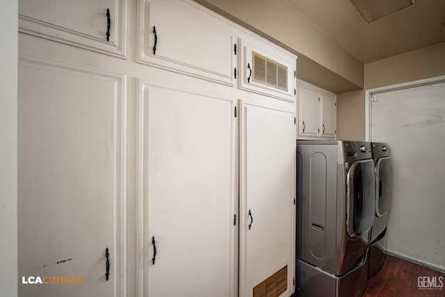 washroom featuring washing machine and clothes dryer, baseboards, dark wood finished floors, and cabinet space