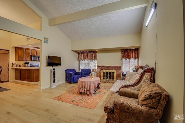 6901 Shelby Loop, Bakersfield, CA 93309 - living area with beamed ceiling, a textured ceiling, light wood finished floors, a fireplace, and high vaulted ceiling