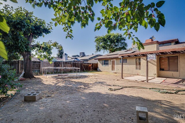 6901 Shelby Loop, Bakersfield, CA 93309 - fenced backyard featuring a trampoline and a patio