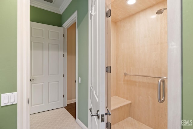 bathroom featuring ornamental molding and a shower with door