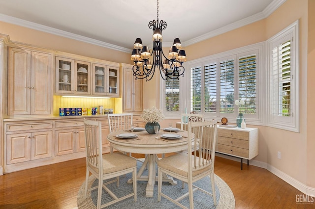 dining space with ornamental molding, a chandelier, and hardwood / wood-style floors