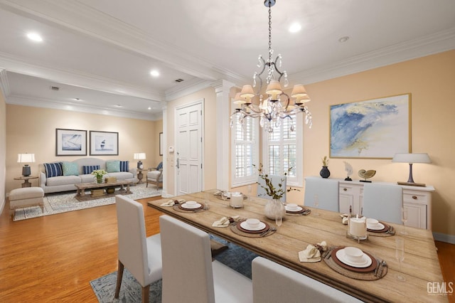 dining area featuring crown molding, light hardwood / wood-style floors, and a notable chandelier