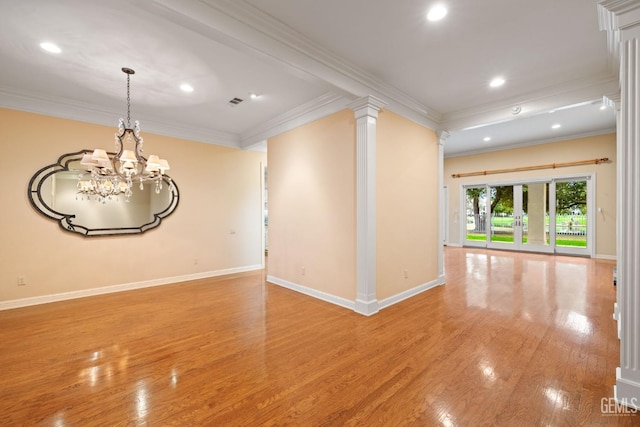 unfurnished room featuring an inviting chandelier, light hardwood / wood-style flooring, ornamental molding, and decorative columns