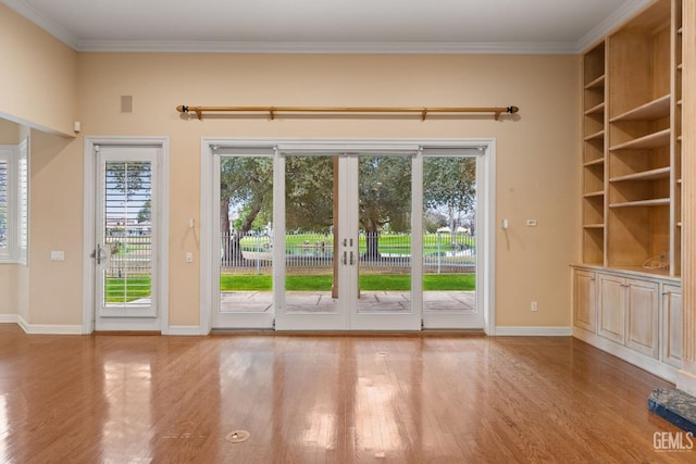 entryway with french doors, ornamental molding, and light hardwood / wood-style floors