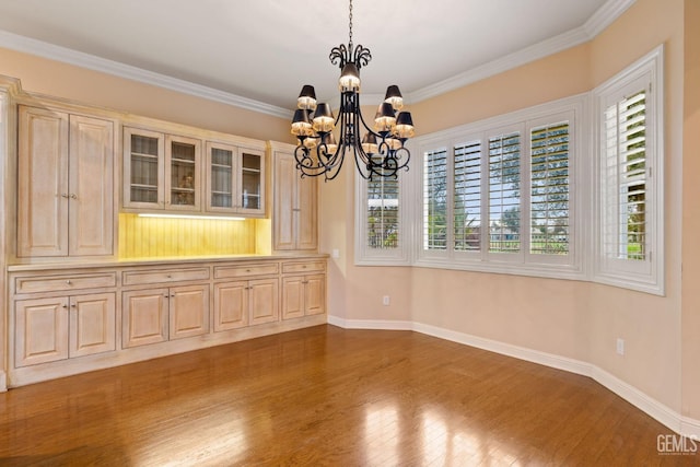 unfurnished dining area featuring ornamental molding, dark hardwood / wood-style floors, and an inviting chandelier