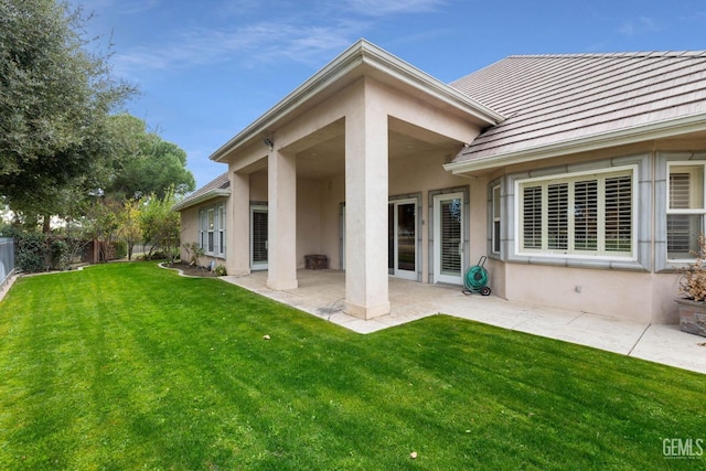 rear view of house with a yard and a patio area