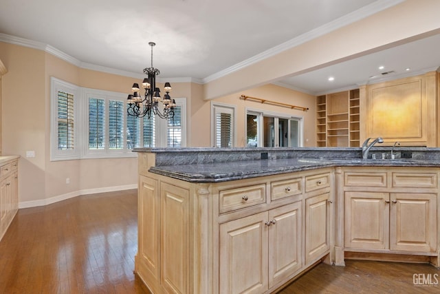 kitchen featuring hardwood / wood-style floors, sink, light brown cabinets, and decorative light fixtures