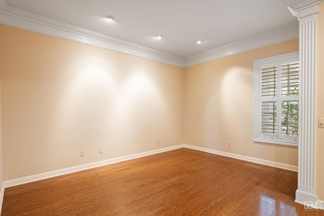 unfurnished room with hardwood / wood-style flooring, ornamental molding, and decorative columns