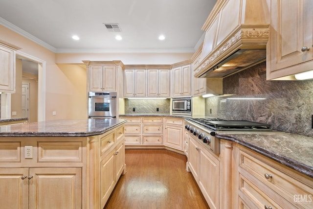 kitchen featuring light brown cabinetry, light hardwood / wood-style flooring, dark stone countertops, ornamental molding, and custom range hood