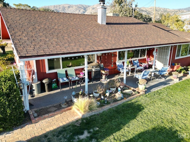 rear view of property with a mountain view and a patio area