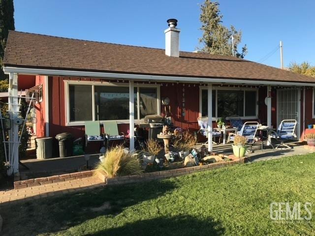 rear view of property featuring a lawn