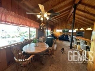 dining room with wooden ceiling, lofted ceiling with beams, carpet flooring, ceiling fan, and log walls