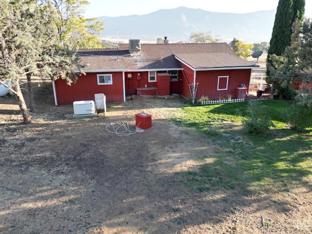 back of property featuring a lawn and a mountain view