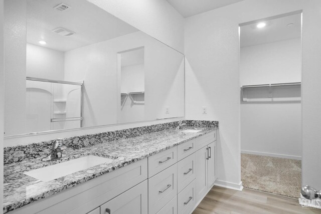 4912 Beaverhead Ave, Bakersfield, CA 93306 - full bath featuring wood finished floors, double vanity, a spacious closet, and recessed lighting