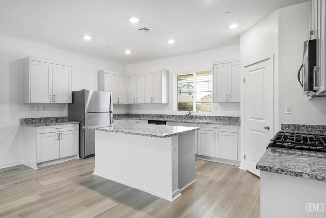 4912 Beaverhead Ave, Bakersfield, CA 93306 - kitchen with stainless steel appliances, light wood finished floors, light stone countertops, a kitchen island, and recessed lighting