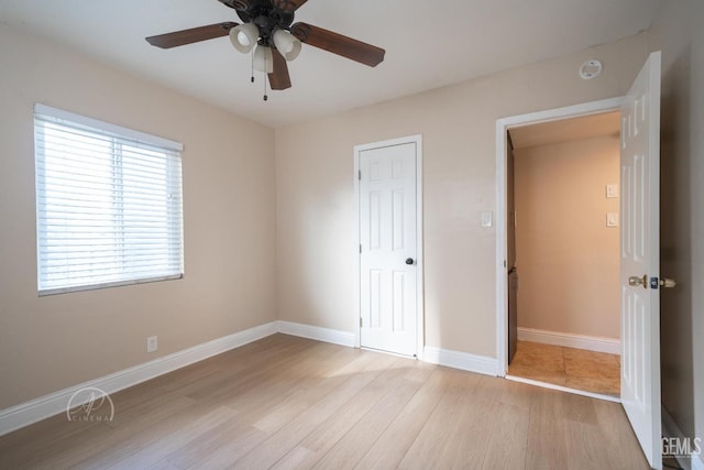 unfurnished bedroom with baseboards, ceiling fan, and light wood finished floors