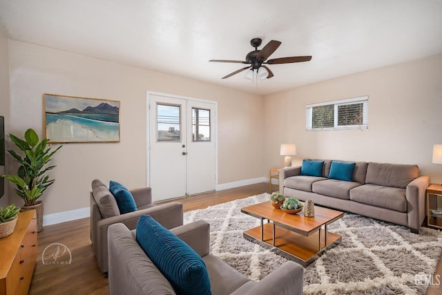 living room with baseboards, a ceiling fan, and wood finished floors