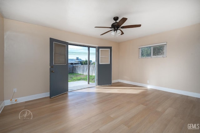 spare room with ceiling fan, baseboards, and light wood-style flooring