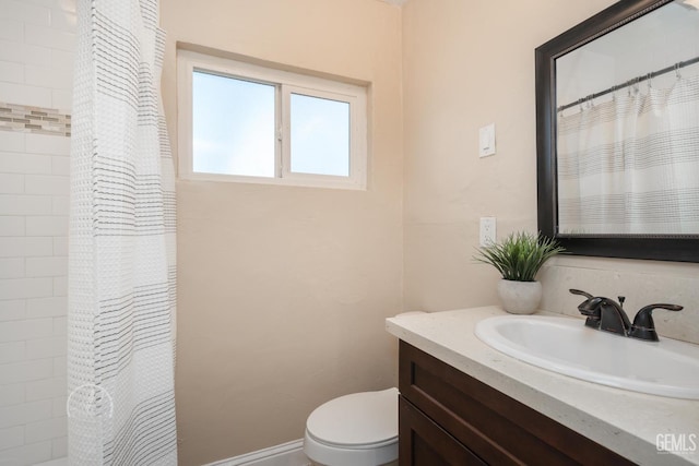 bathroom with a shower with shower curtain, baseboards, toilet, and vanity