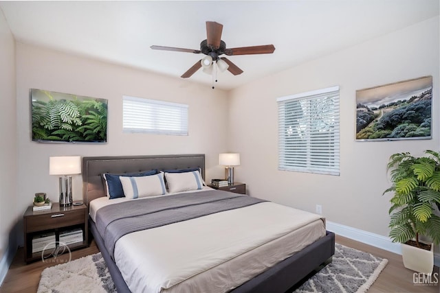 bedroom featuring wood finished floors, baseboards, and ceiling fan